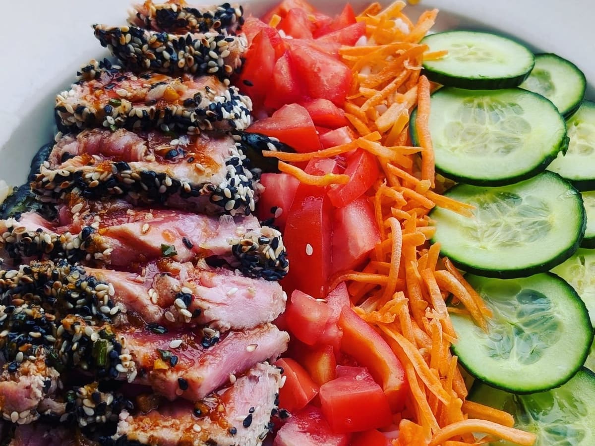 Seared sesame ahi tuna over greens with tomato, carrot and cucumber